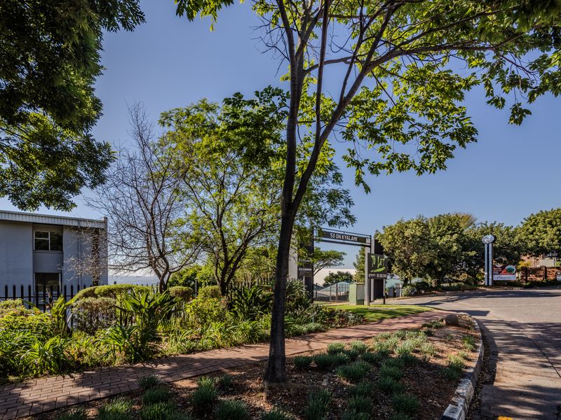 Exterior view of the office property entrance featuring landscaped gardens, paved walkways, and clear signage for 53 on Kyalami.