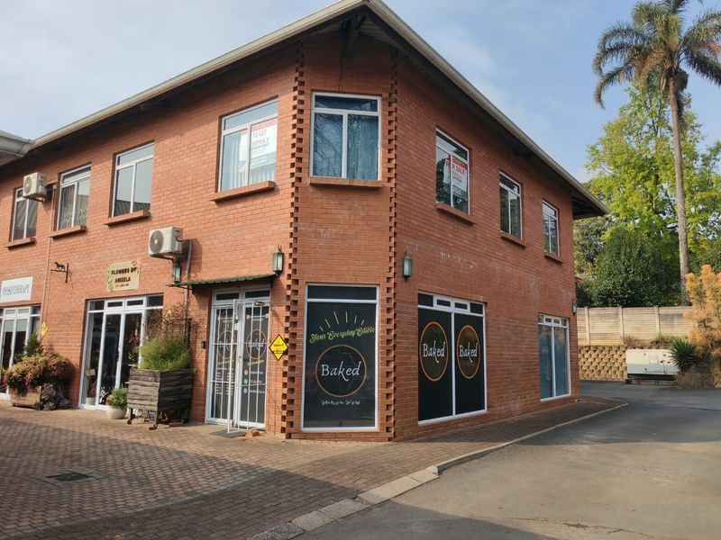 Exterior view of a two-story brick commercial apartment building featuring paved access, aluminium windows, and external air conditioning units.