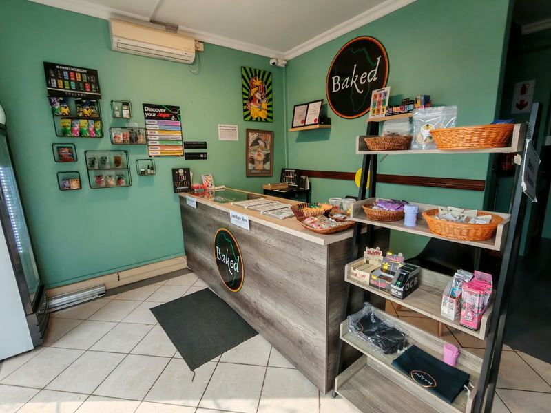 A commercial retail space featuring a built-in service counter, tiled flooring, and wall-mounted air conditioning unit.