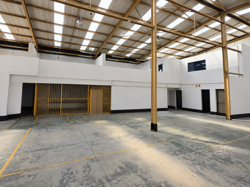 Spacious industrial utility area featuring a high steel portal frame roof, translucent panels for natural light, concrete flooring, and a secure caged storage section.