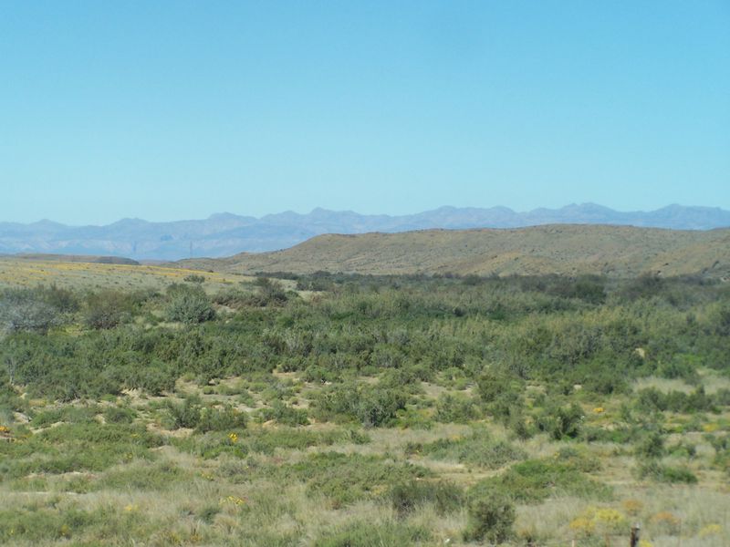 A scenic landscape view showcasing the expansive natural terrain and distant mountain ranges characteristic of the farm property.