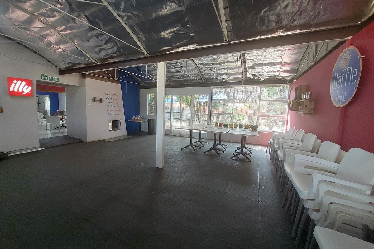 Open-plan restaurant dining area featuring large windows, tiled flooring, and an exposed insulated ceiling structure.