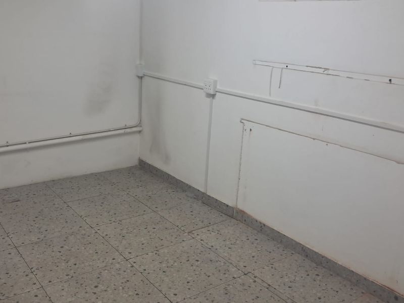 An empty utility space featuring terrazzo flooring and surface-mounted electrical conduits, requiring cosmetic updates to the wall finishes.