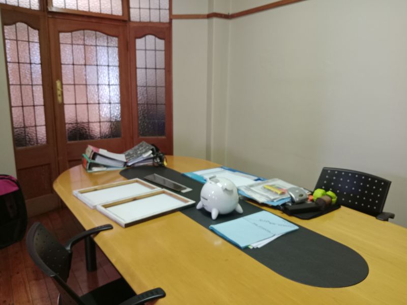 A functional office space featuring traditional timber flooring and a classic leaded glass timber door, providing a professional atmosphere.
