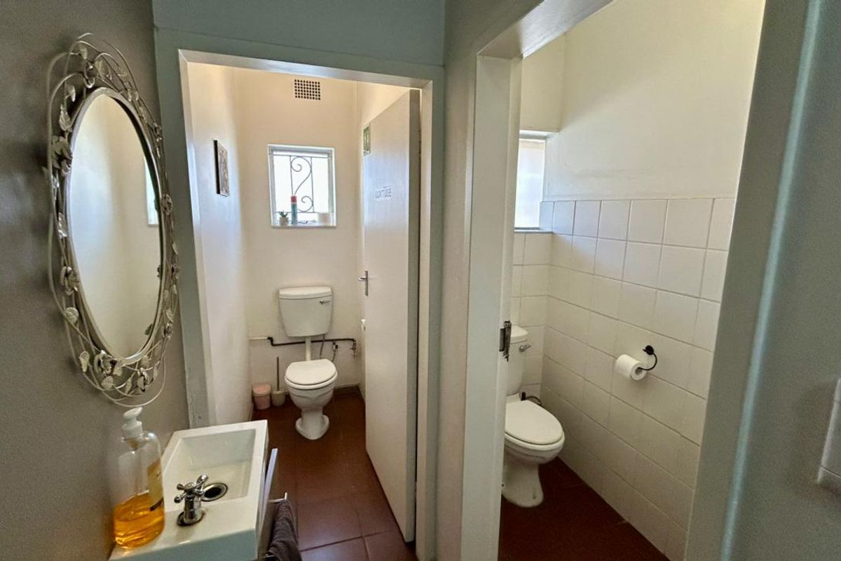Two separate restroom facilities featuring tiled floors, wall-mounted basins, and standard ceramic toilets in a functional office setting.