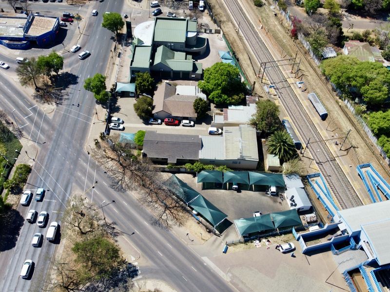 Aerial view of the office property showing the building complex, associated parking facilities with shade cloth carports, and proximity to the adjacent railway line.