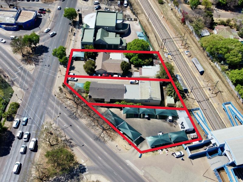 Aerial view of the office property featuring multiple buildings, paved parking areas with shade cloth carports, and convenient access to main roads and rail.