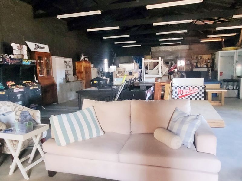 Spacious industrial utility area featuring exposed timber roof trusses, concrete flooring, and blockwork walls, suitable for workshop or storage use.