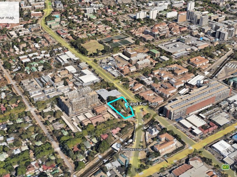Aerial view of a vacant commercial land plot located in a developed urban area.
