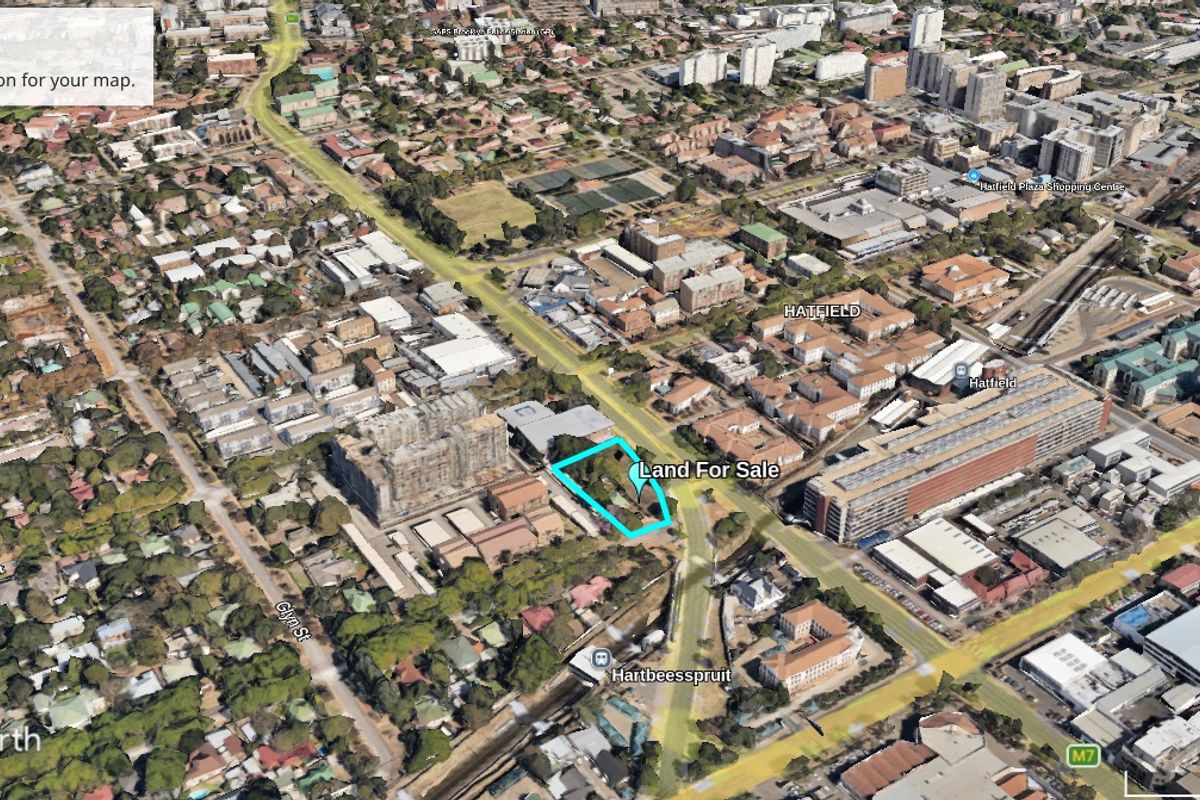Aerial view of a vacant commercial land plot located in a developed urban area.