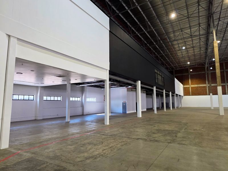Spacious industrial warehouse interior featuring high ceilings with exposed steel trusses, concrete flooring, and large open-plan layout suitable for various commercial or storage uses.