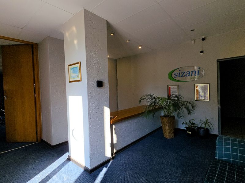 Professional office reception area featuring a built-in service counter, carpeted flooring, and recessed ceiling lighting.