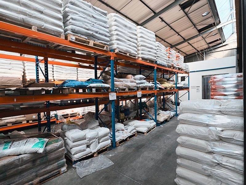 Industrial warehouse space featuring high-capacity steel racking systems, exposed roof trusses, and durable concrete flooring, suitable for large-scale storage and logistics operations.