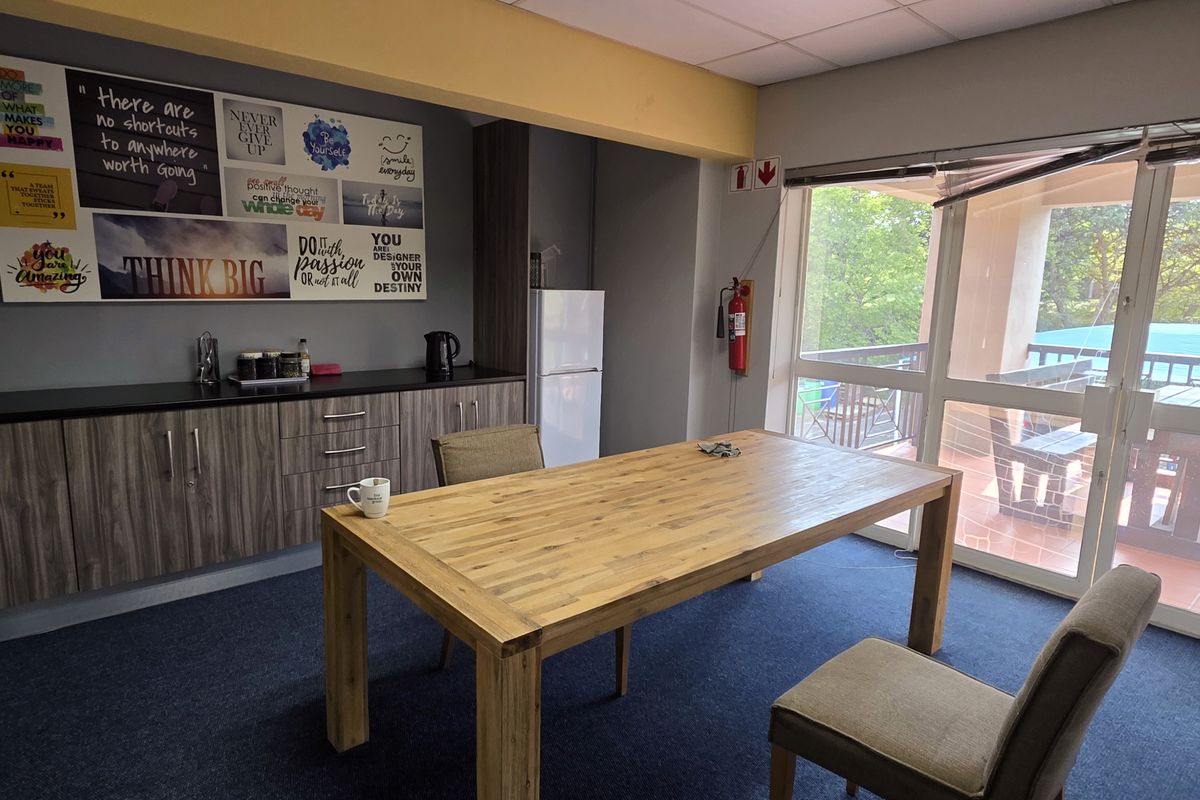 A functional kitchenette area featuring built-in cabinetry, a sink, and direct access to an outdoor patio through sliding glass doors.