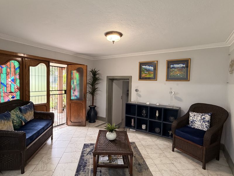 A welcoming reception area featuring tiled flooring, crown molding, and a distinctive stained glass entrance door.