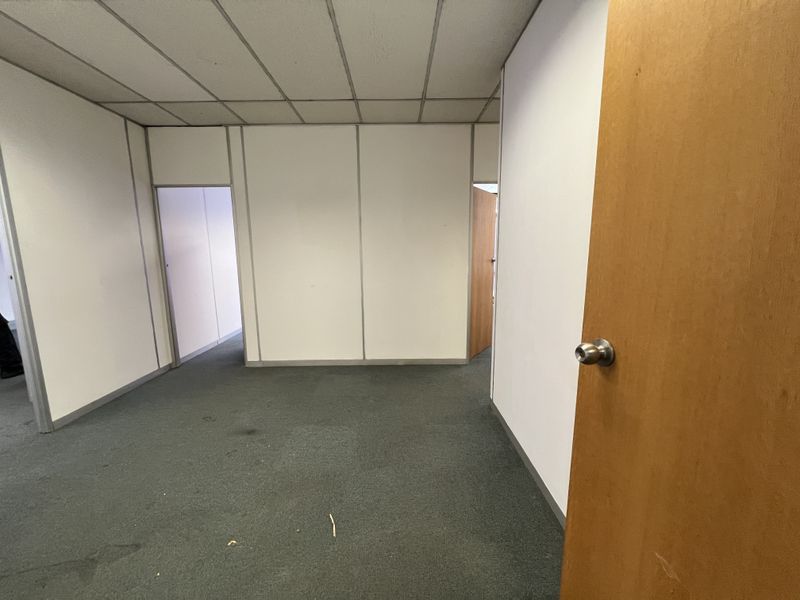 An empty office space featuring suspended ceilings, partition walls, and carpeted flooring, ready for customization or professional fit-out.