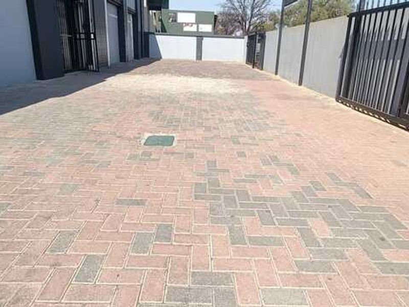 A paved exterior driveway and parking area featuring secure perimeter fencing and gated access to the business premises.