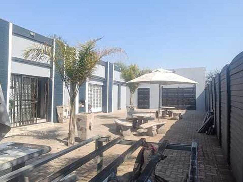 Outdoor courtyard area featuring paved flooring, perimeter fencing, and access to the main building structure.