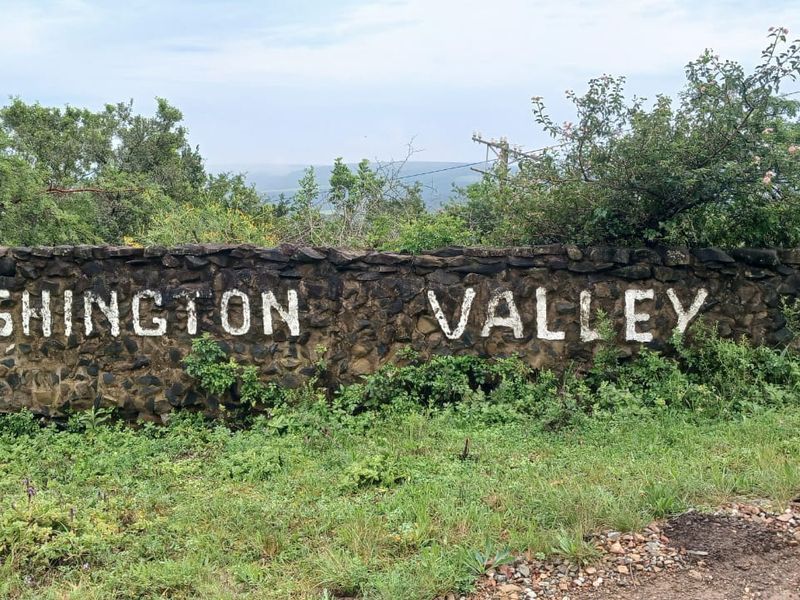 A rustic stone boundary wall featuring the property name, Lushington Valley, marking the entrance to the farm estate.