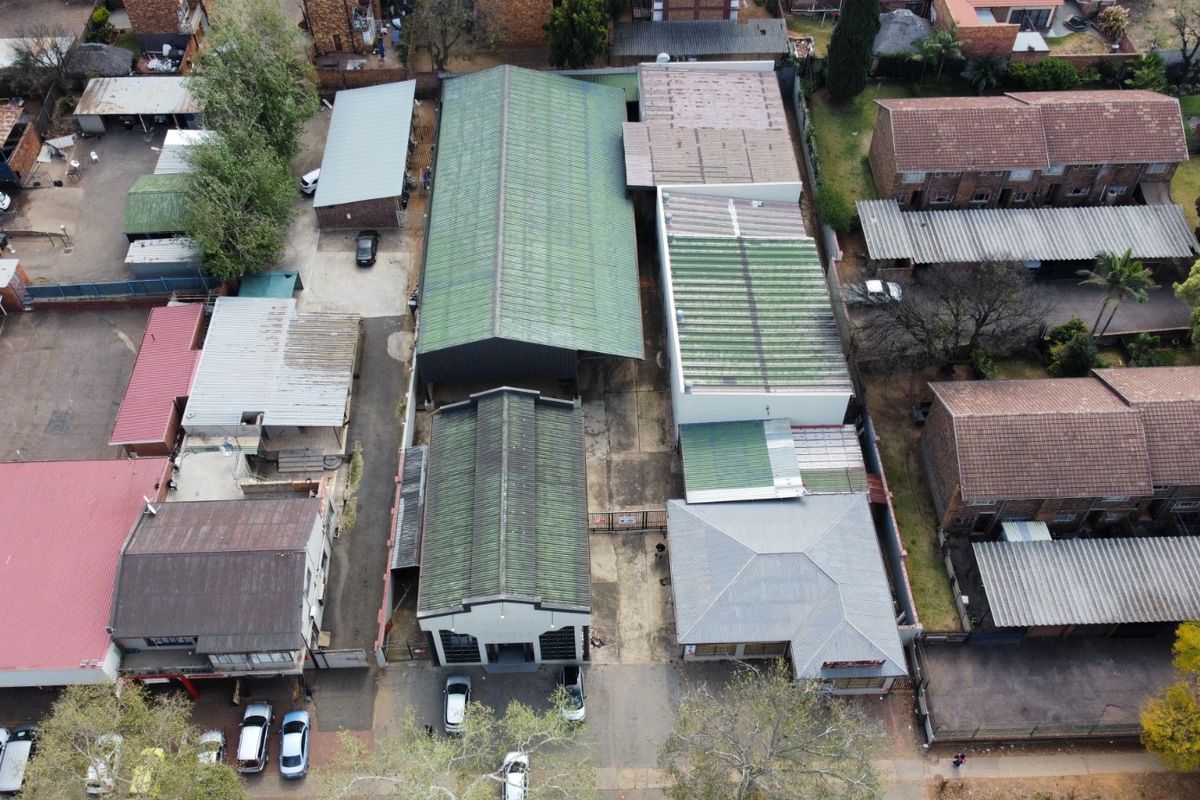 Aerial view of an industrial property complex featuring multiple warehouse structures with corrugated metal roofing and paved access areas.