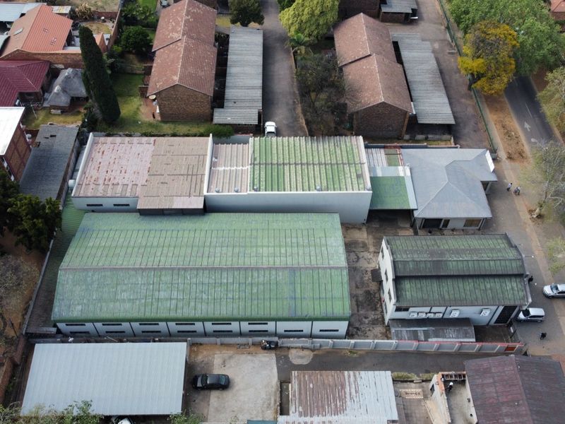 Aerial view of an industrial property complex featuring multiple warehouse buildings with corrugated metal roofing and paved access areas.