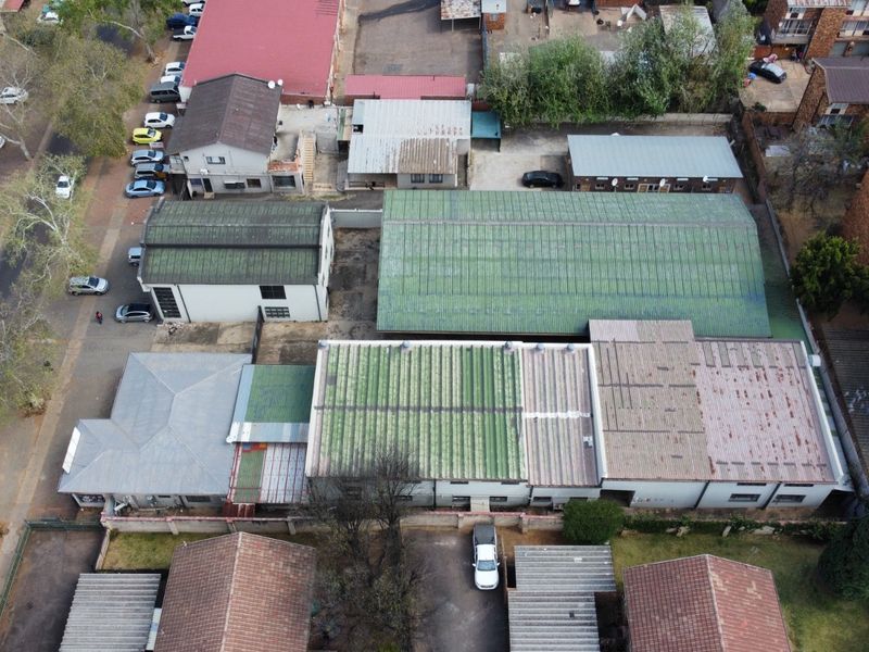 Aerial view of an industrial property complex featuring multiple warehouse buildings with corrugated metal roofing and surrounding paved yard areas.