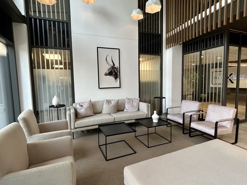 Modern office reception area featuring double-volume ceilings, contemporary glass partitions, and high-quality finishes in a professional corporate environment.