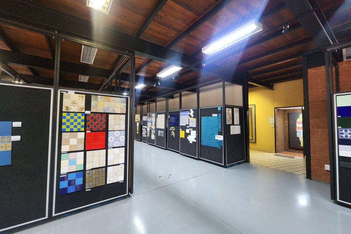 Industrial style showroom or commercial space featuring exposed timber ceilings, steel beams, epoxy flooring, and modular partition walls for product display.