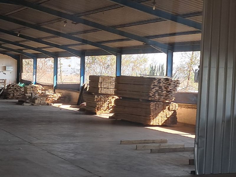 Spacious industrial utility area featuring a steel portal frame structure, corrugated metal roofing, and durable concrete flooring, suitable for storage or workshop use.