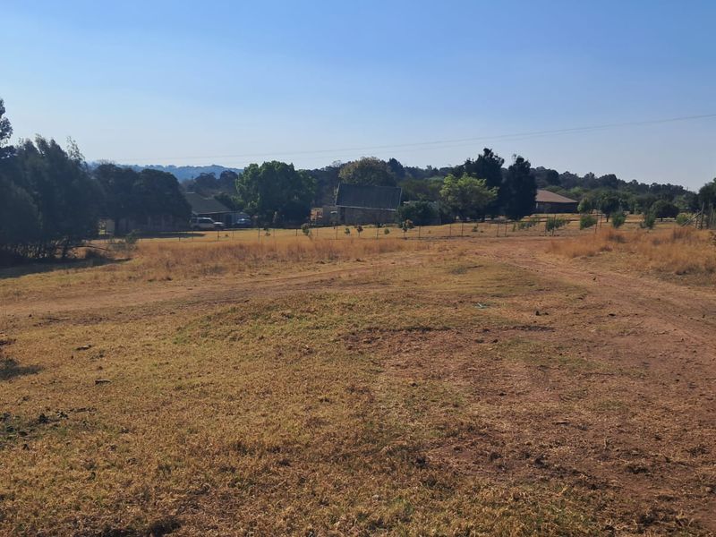 Expansive undeveloped land area featuring natural grass cover, perimeter fencing, and an unpaved access track, suitable for industrial development.