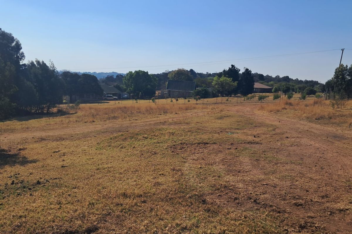Expansive undeveloped land area featuring natural grass cover, perimeter fencing, and an unpaved access track, suitable for industrial development.