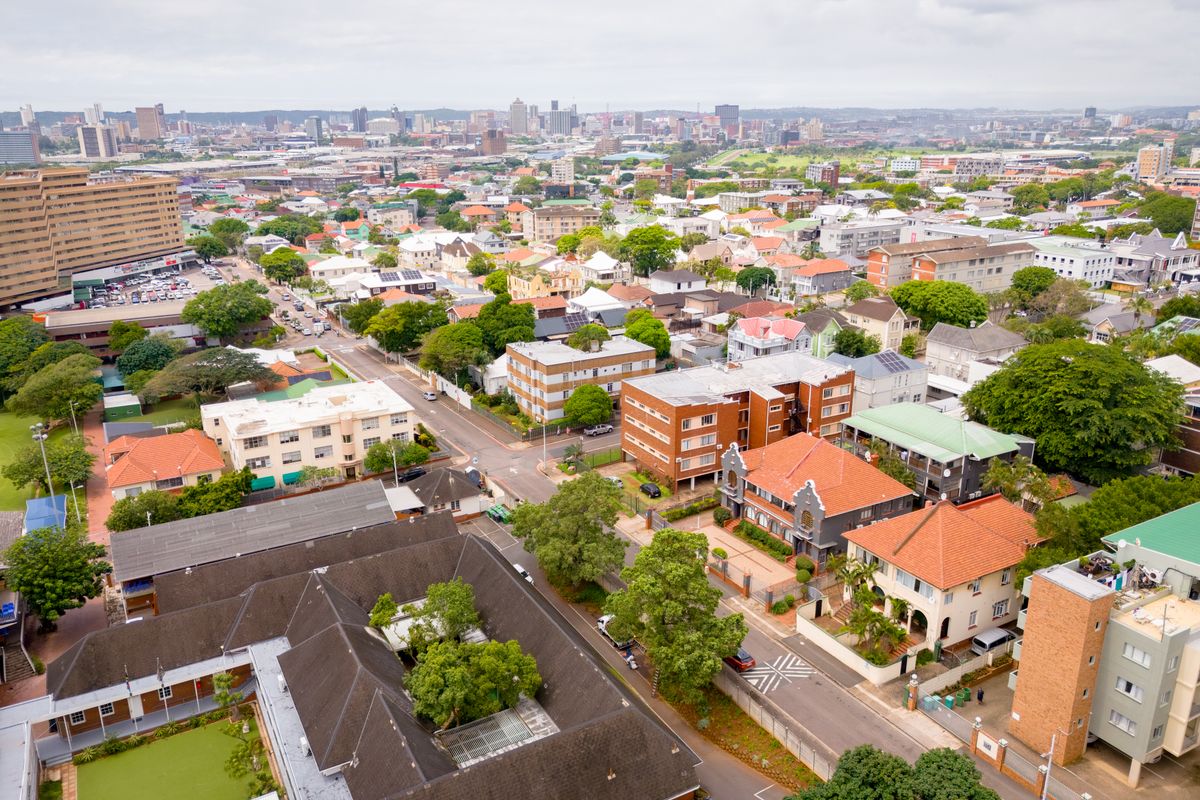 An elevated aerial view showcasing the surrounding urban landscape, neighborhood infrastructure, and city skyline.