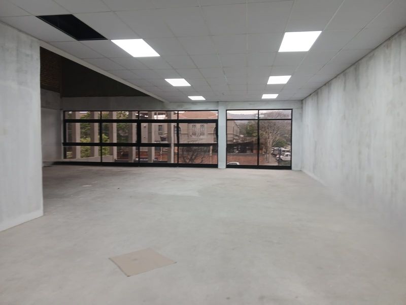 An open-plan office space in shell condition featuring large windows, recessed lighting, and unfinished walls, offering a blank canvas for custom fit-out.