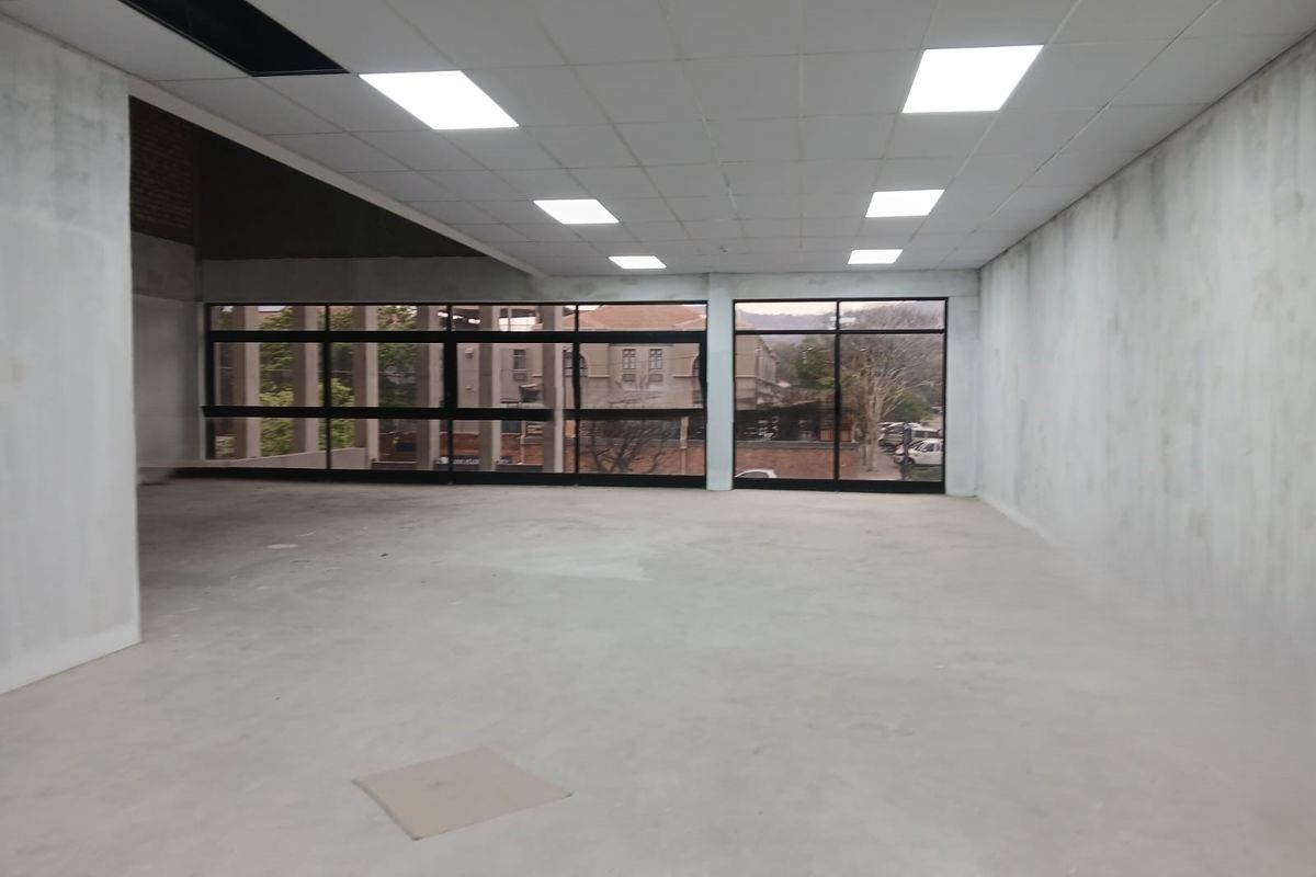 An open-plan office space in shell condition featuring large windows, recessed lighting, and unfinished walls, offering a blank canvas for custom fit-out.