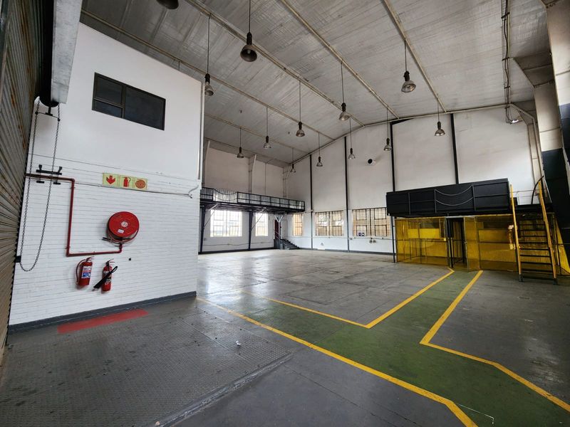 Spacious industrial warehouse unit featuring high ceilings, mezzanine level, integrated fire safety equipment, and durable flooring suitable for various commercial or manufacturing operations.