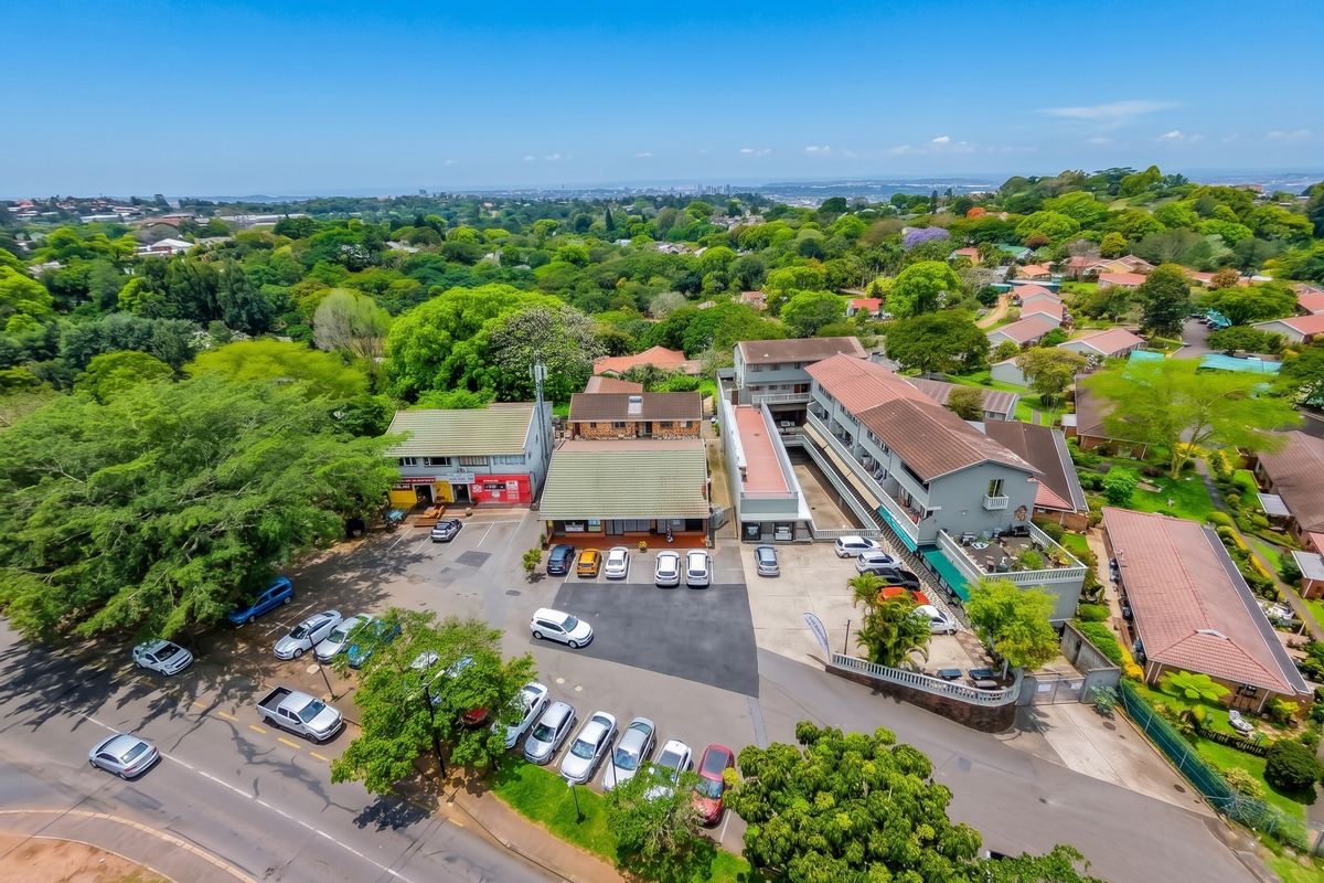 Aerial view of a commercial property complex featuring multiple buildings, extensive paved parking areas, and surrounding landscaped grounds in a suburban setting.