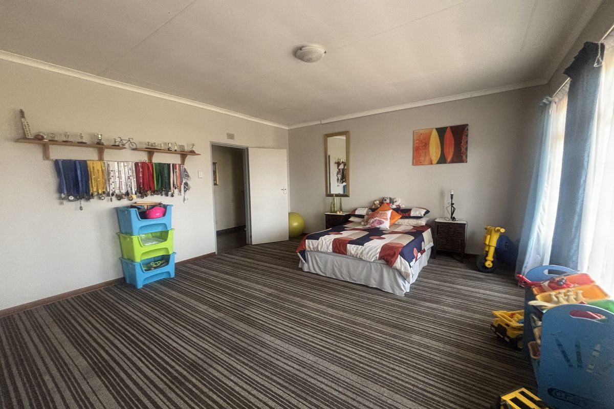 Spacious bedroom featuring fitted carpeting, neutral wall finishes, and a ceiling light fixture, offering a versatile layout for various furniture arrangements.