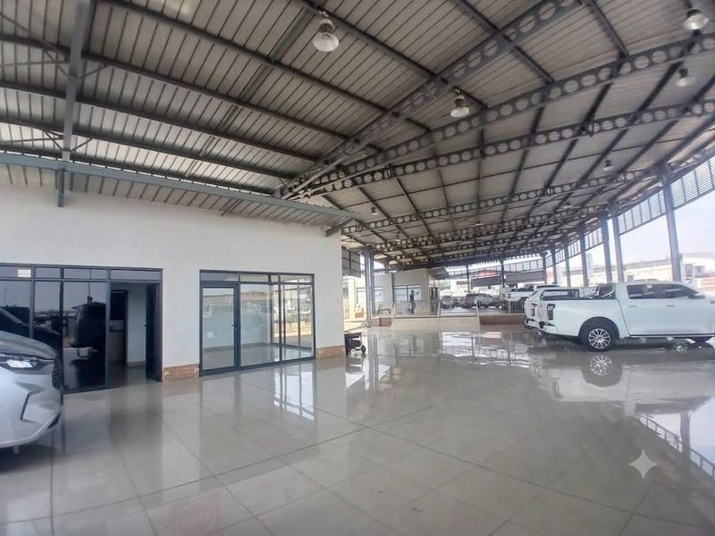 Spacious open-plan commercial utility area featuring high-clearance steel roofing, polished tiled floors, and modern glass-partitioned office or display enclosures.