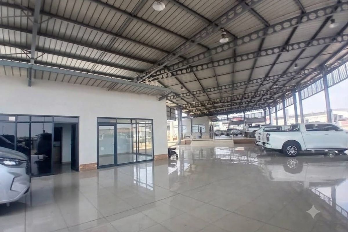 Spacious open-plan commercial utility area featuring high-clearance steel roofing, polished tiled floors, and modern glass-partitioned office or display enclosures.