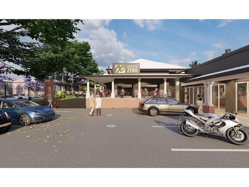 Front exterior view of a retail property featuring a covered patio area, brick retaining wall, and paved parking facilities.