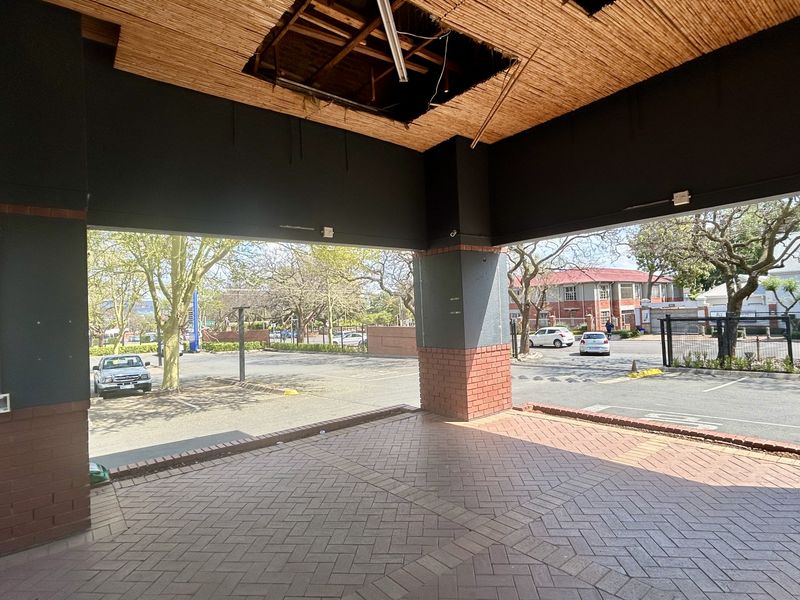 Covered outdoor patio area featuring brick paving and pillars, currently requiring repairs to the ceiling structure.