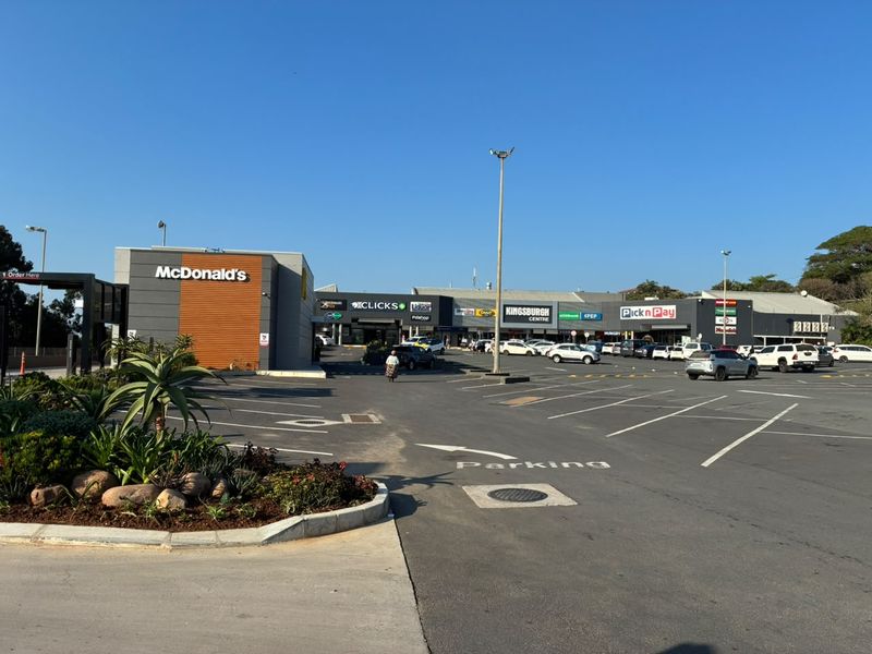Exterior view of Kingsburgh Centre retail complex featuring a McDonald's drive-thru, paved parking area, and various established retail storefronts.