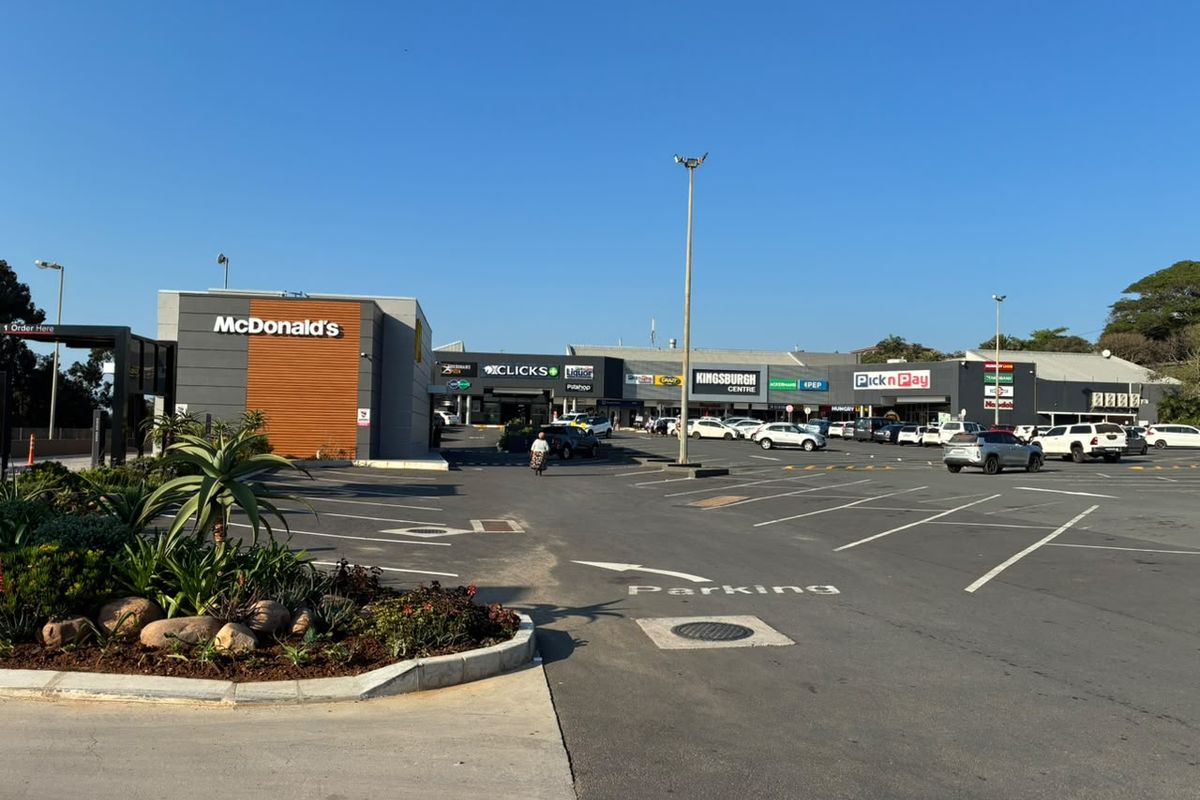 Exterior view of Kingsburgh Centre retail complex featuring a McDonald's drive-thru, paved parking area, and various established retail storefronts.