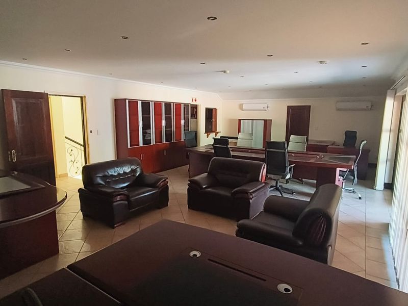 Spacious office area featuring tiled flooring, recessed lighting, built-in storage cabinetry, and dual split-system air conditioning units for climate control.