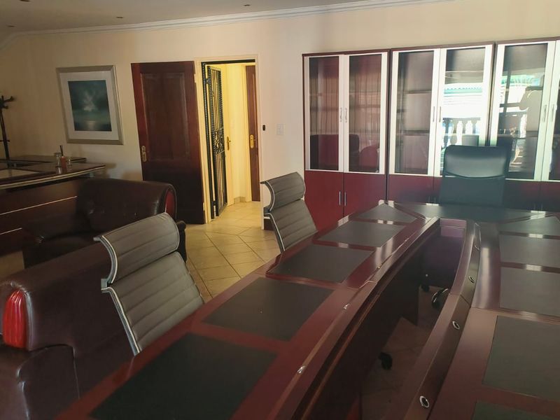A professional office space featuring built-in cabinetry, tiled flooring, and recessed lighting, providing a functional and structured work environment.