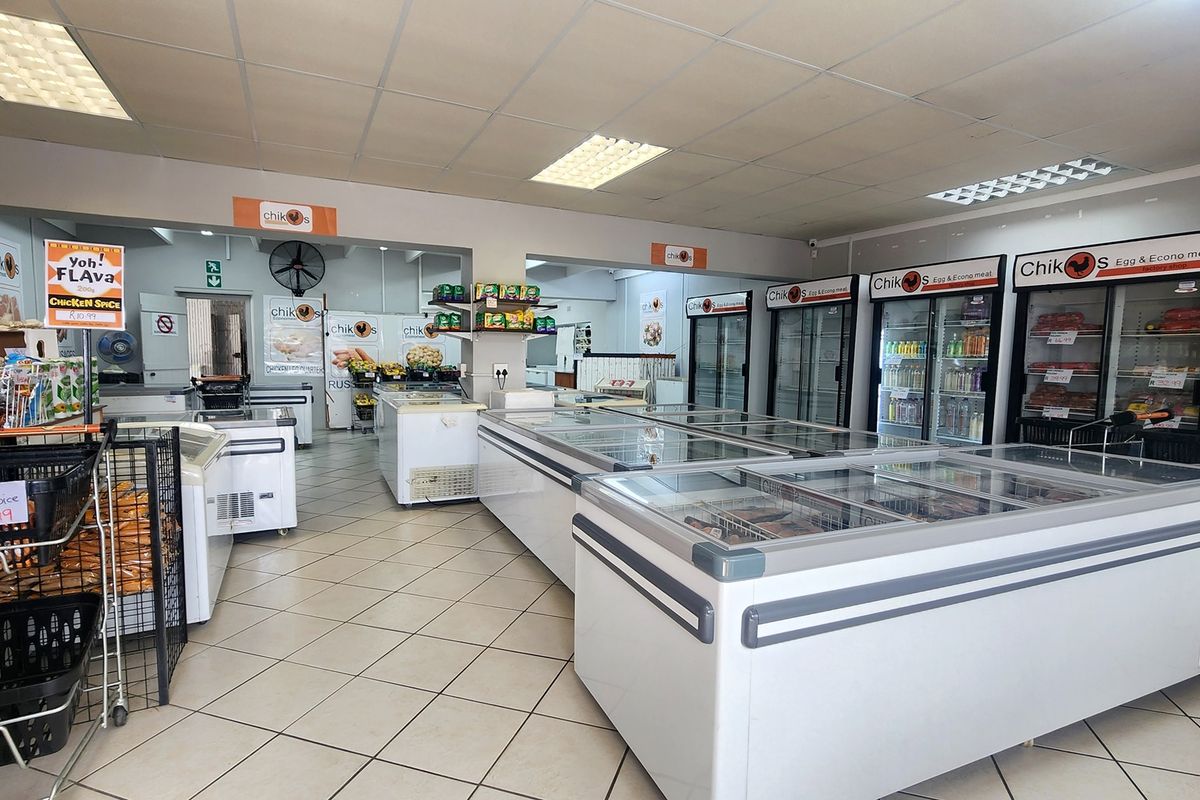 A well-maintained retail space featuring a suspended ceiling, tiled flooring, and multiple commercial refrigeration units for food display.
