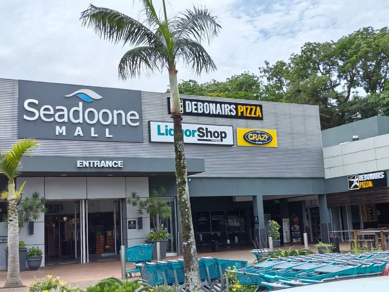 Front entrance view of Seadoone Mall featuring prominent retail signage, modern metal cladding, and a paved customer forecourt area.