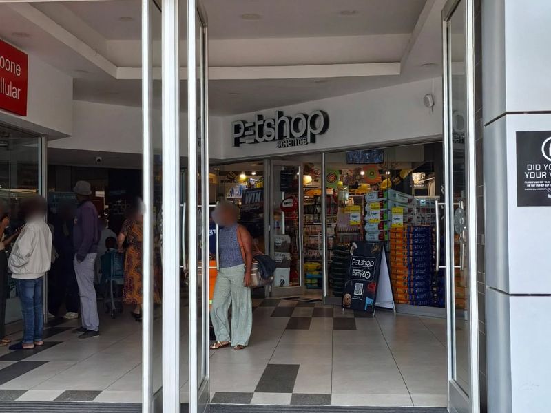 Entrance area of a retail center featuring glass storefront doors, tiled flooring, and clear signage for the commercial units.