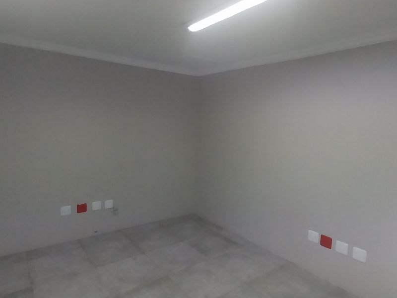 A clean, empty office space featuring neutral wall finishes, tiled flooring, and integrated electrical and data connectivity points.