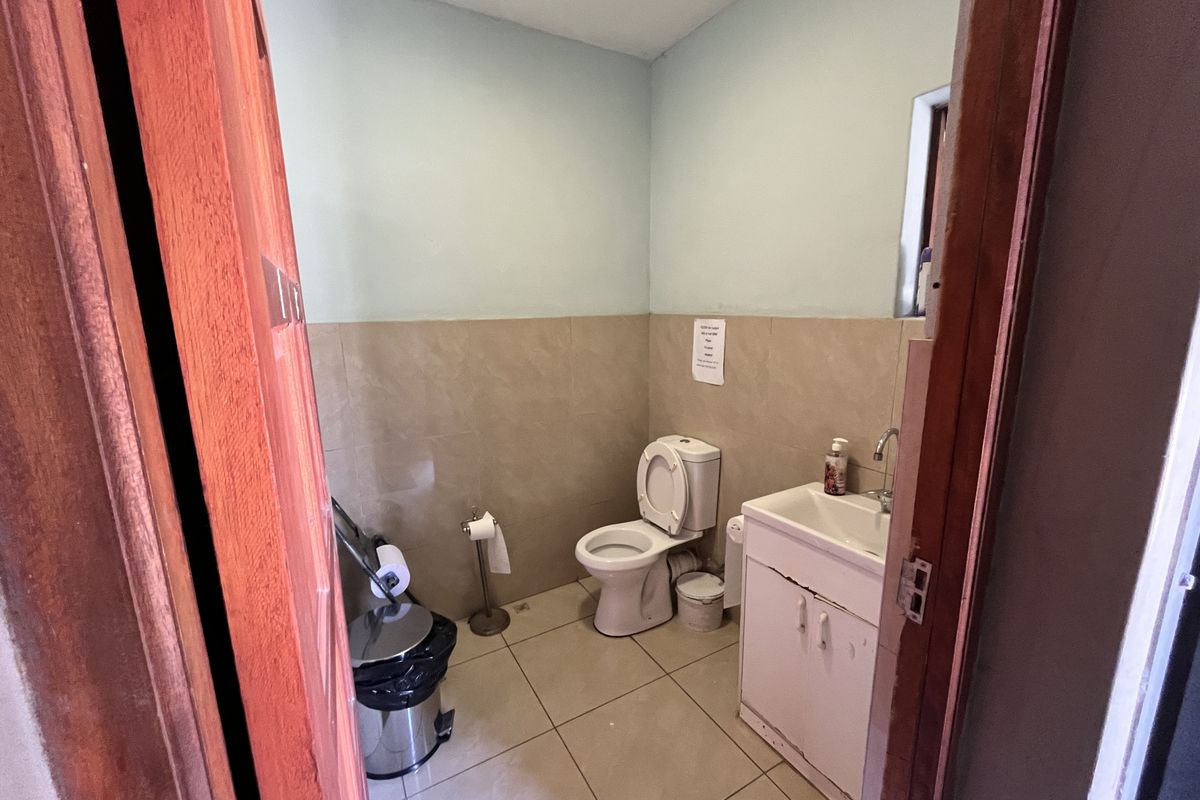 A functional bathroom featuring tiled walls, a standard toilet, and a vanity basin unit.